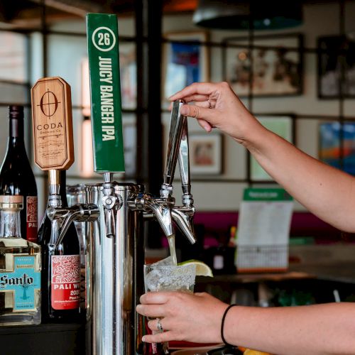 A person is pouring beer into a glass from a tap labeled 